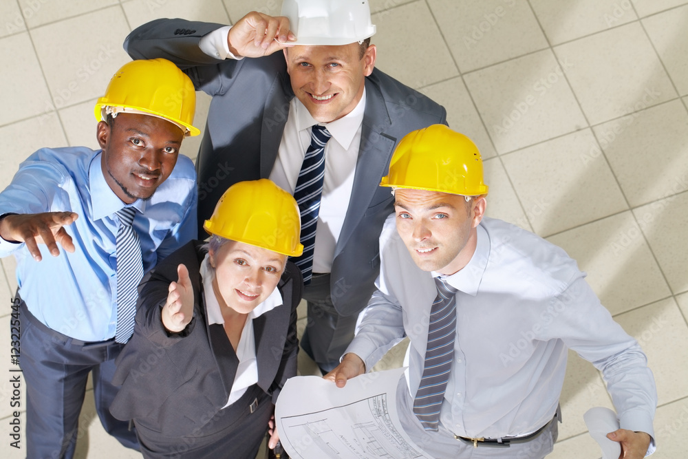 Above view of four engineers looking up and smiling Above view of four engineers looking up and smiling