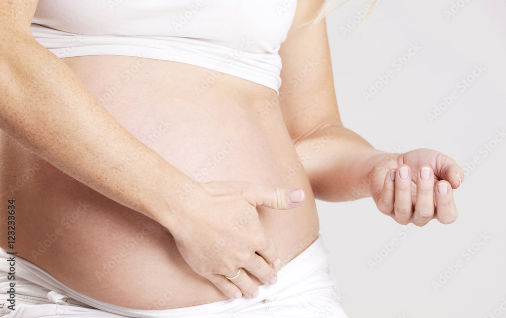 Pregnant belly woman applying moisturizer