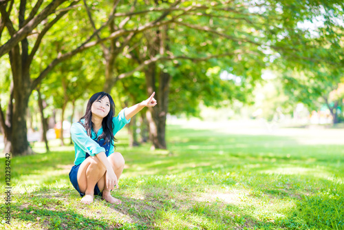Women enjoying nature in green meadow with branch of tree