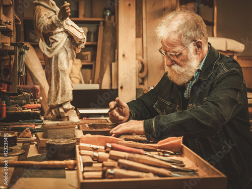 Bilde på lerret Senior restorer working with antique decor element in his workshop