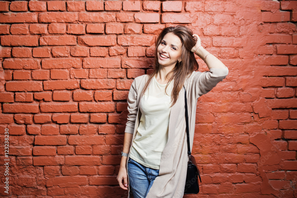 Young beautiful happy woman in casual cloths against brick wall Young beautiful happy woman in casual cloths against brick wall