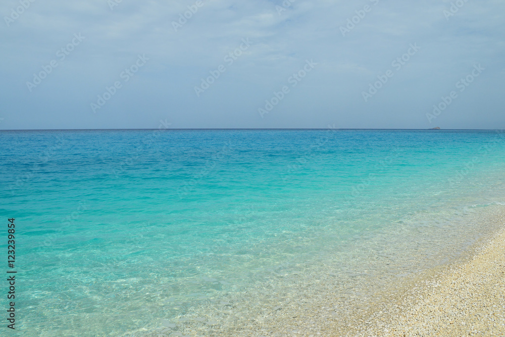 Calm tropical sea with limpid emerald water and sandy beach