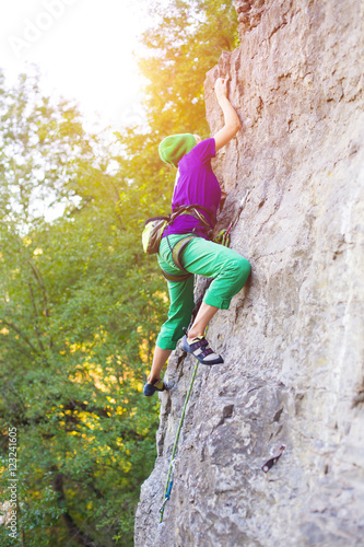 The girl climbs the rock.