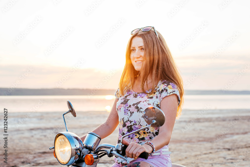 Young pretty woman with tattoo riding a bike and enjoing the sunset at the seaside Young pretty woman with tattoo riding a bike and enjoing the sunset at the seaside