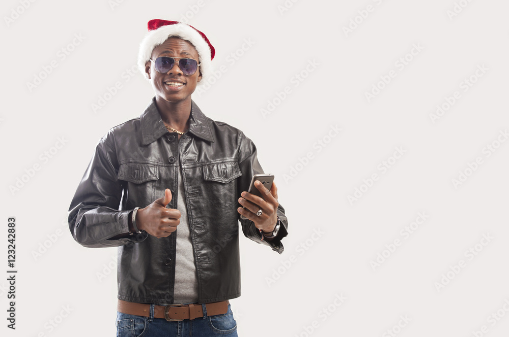 Happy young african american man using his mobile in christmas hat Happy young african american man using his mobile in christmas hat