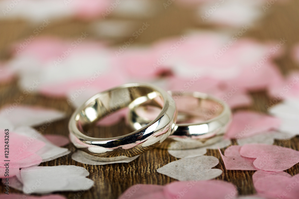 wedding rings on a wooden background with confetti wedding rings on a wooden background with confetti