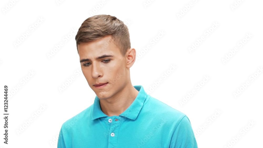 Upset young man looking at camera over white background Slow motion Upset young man looking at camera over white background Slow motion