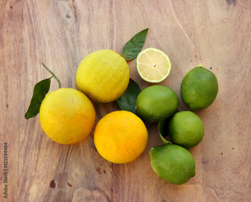 Different refreshing citrus fruits. Cocktail ingredients.Fresh fruits citruses on a dark wooden background. Fruit set.Green lemon