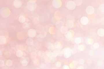 Bokeh soft pastel pink background with blurred golden lights. Festive background.