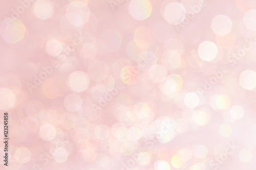 Bokeh soft pastel pink background with blurred golden lights. Festive background.