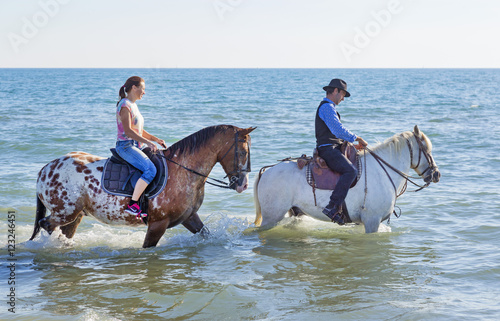 riders and horses in the sea
