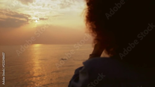Beautiful female phorograph taking picture of sunrise at sea photo