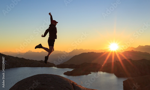 Man jumping out of joy during a clear sunset at a lake near Chamonix.