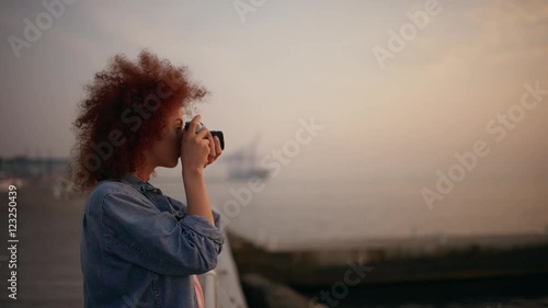 Beautiful female phorograph smiling taking picture at seaside Slow motion photo