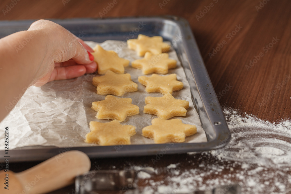 Cookie cutters and shortbread shapes on a board and a baking tra Cookie cutters and shortbread shapes on a board and a baking tra