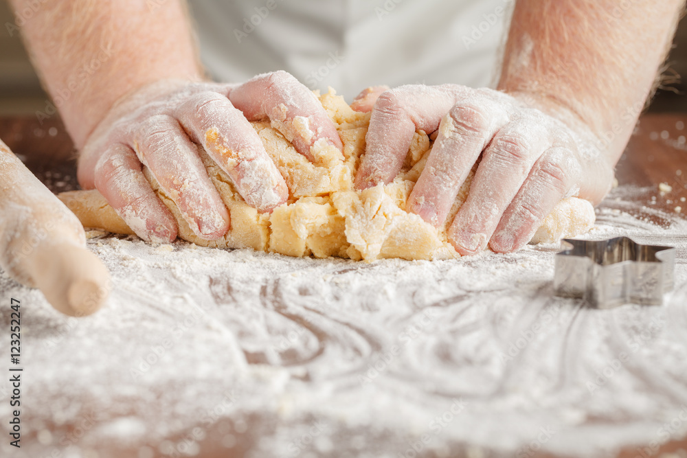 Making dough by mens hands on wooden table background Making dough by mens hands on wooden table background