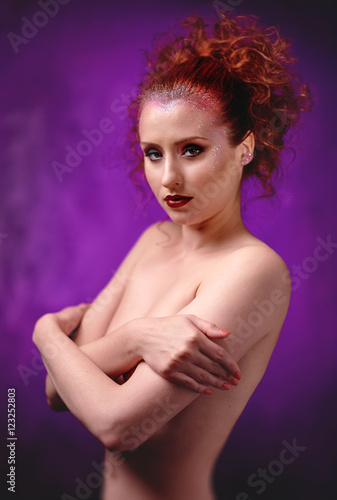 Red-haired woman topless with a bright make-up