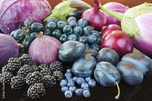 Blue and purple food. Berries, fruits and vegetables on a black background.