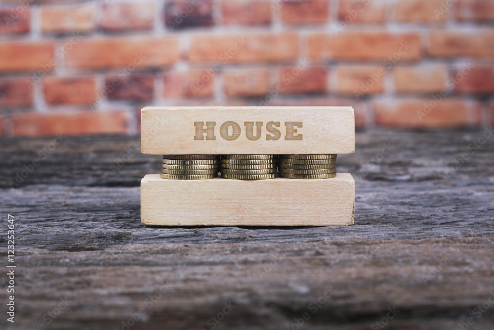 Business Concept - HOUSE word Golden coin stacked with wooden bar Business Concept - HOUSE word Golden coin stacked with wooden bar