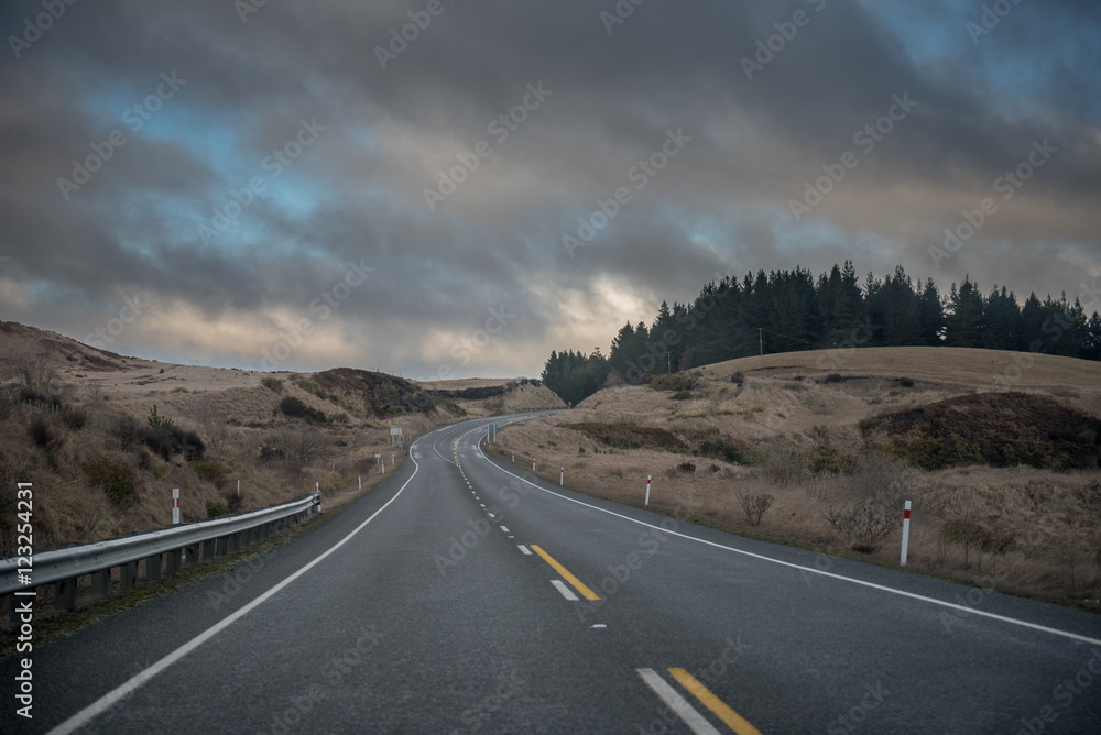 Fototapeta premium empty road curving to the right at dusk
