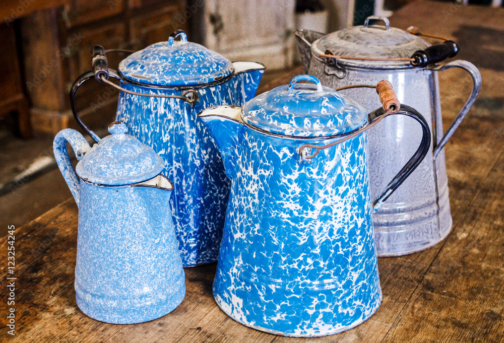 Antique granite-ware, speckle-ware, enamelware, agate-ware, coffee pots.  Four pots in all. Two cobalt blue and white swirl, one grey and white  mottled one light blue and white speckled. Stock Photo
