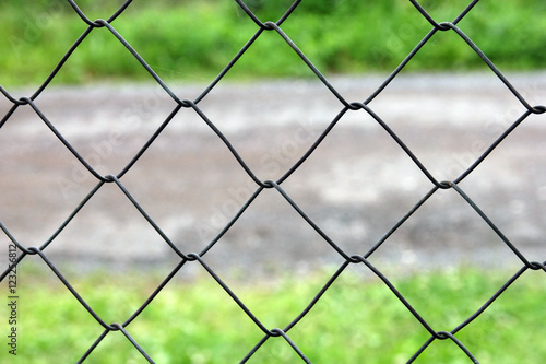 mesh netting galvanized on the background of the road and grass