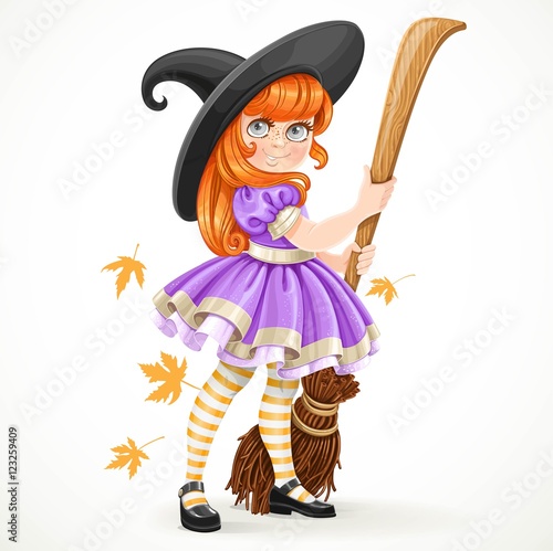 Cute redhead girl dressed as a witch holding a broom for flying