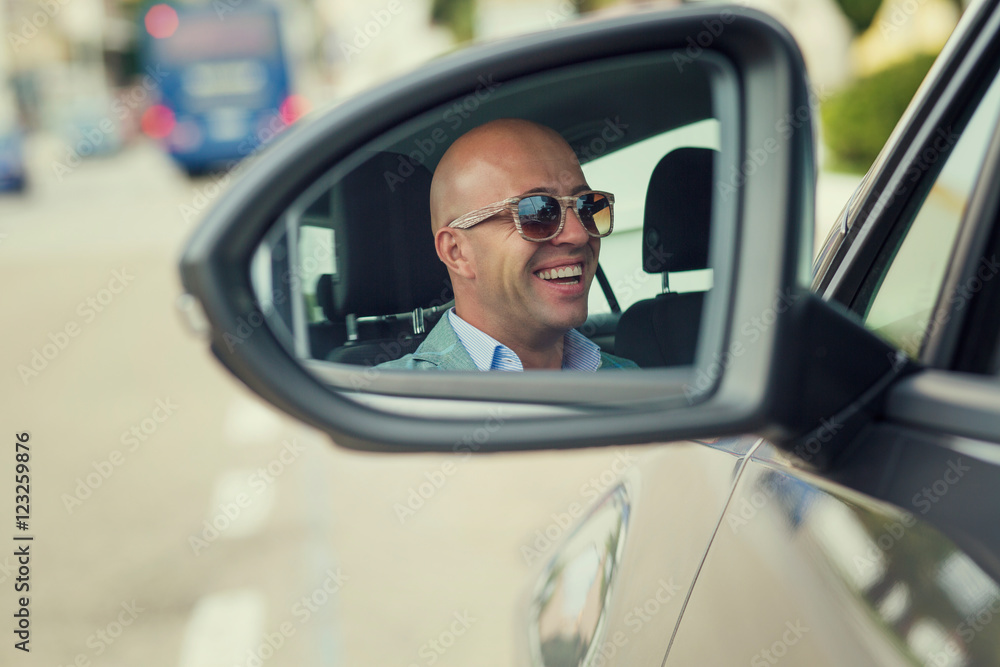 Closeup portrait of side view mirror car reflection of handsome