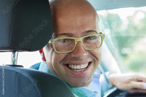 Portrait happy handsome young man in new car hands on wheel, tur © hbrh