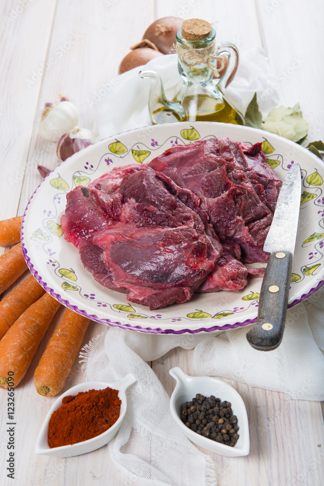 Carne de carrilleras de ternera e ingredientres frescos para preparar la comida