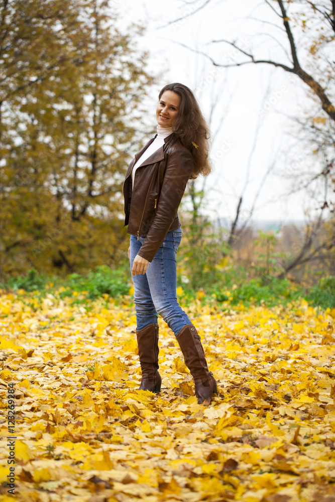 Autumn fashion image of young woman walking in the park Autumn fashion image of young woman walking in the park