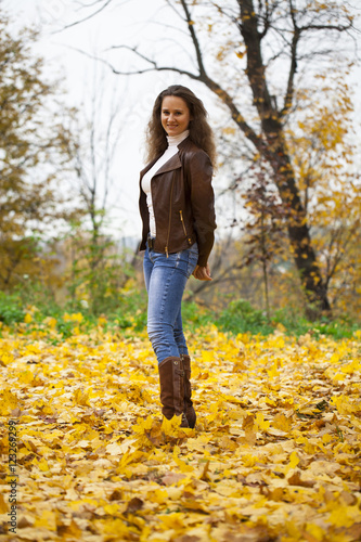 Autumn fashion image of young woman walking in the park © Andrey_Arkusha
