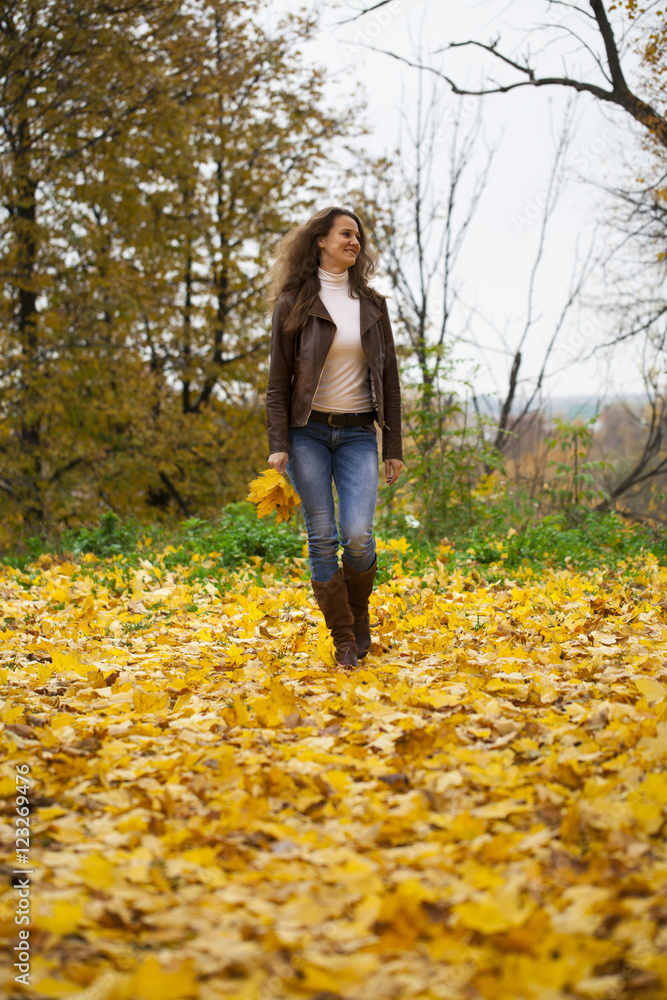Autumn fashion image of young woman walking in the park Autumn fashion image of young woman walking in the park