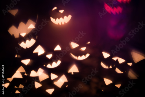 Dark Halloween background. Halloween evil face made of shining lights, garland.