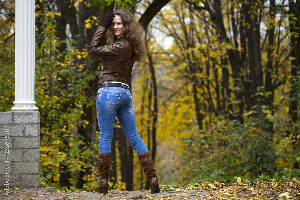 Autumn fashion image of young woman walking in the park Autumn fashion image of young woman walking in the park