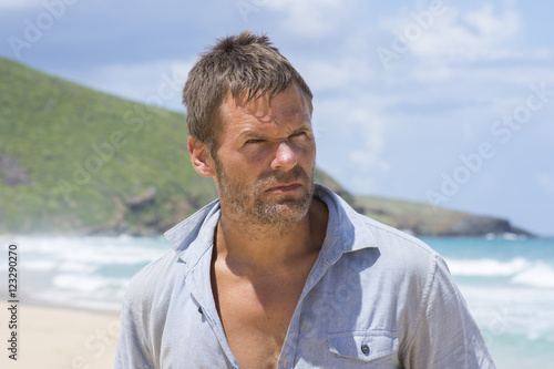 Rugged castaway man on deserted island