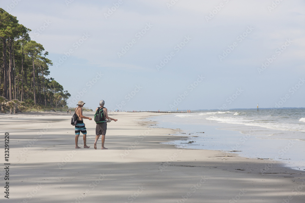 Two male teens strolling on a beach Two male teens strolling on a beach