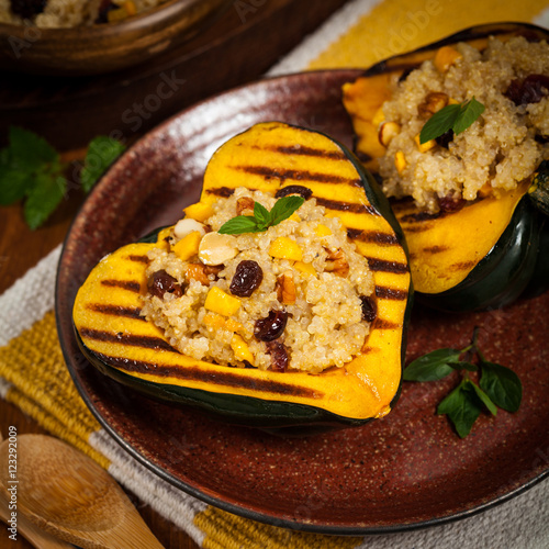 Pumpkin Acorn Stuffed with Quinoa, Nuts and Dried Fruit. Selective focus.