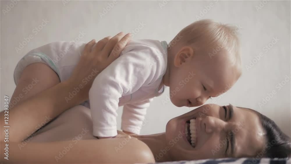 happy family. mother playing with her baby in the bedroom. Laughing and smiling. Happy family on home isolation during coronavirus quarantine