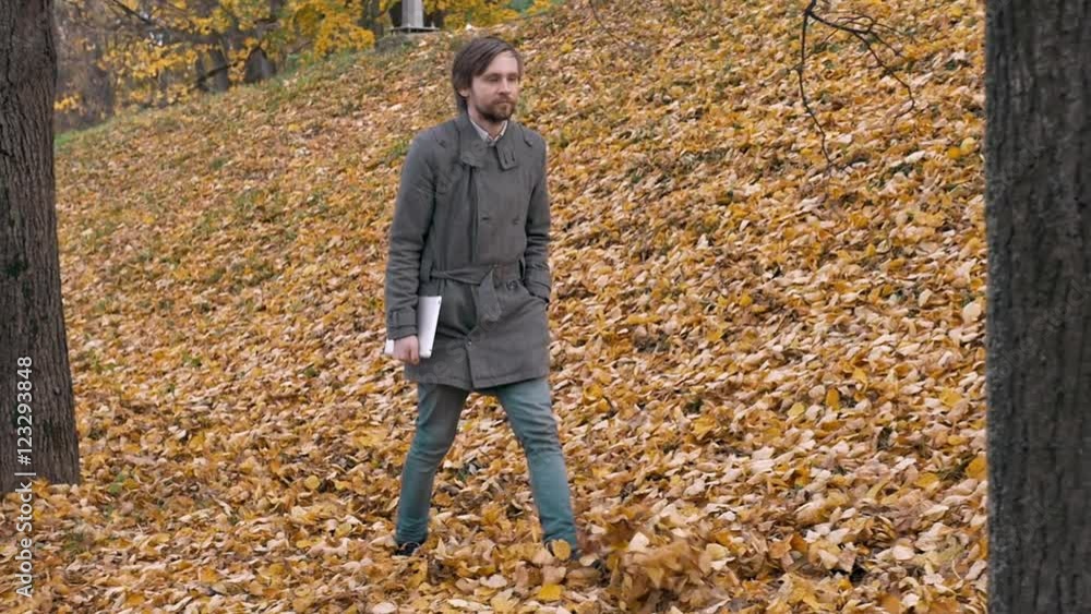 Portrait of a romantic man with beard walking into the forest autumm with tablet. Handsome student in park. Portrait of a romantic man with beard walking into the forest autumm with tablet. Handsome student in park.