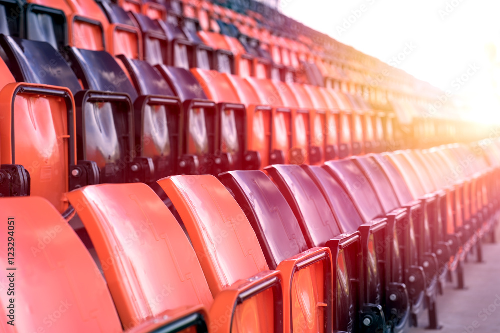Fototapeta premium Rows of black and red plastic stadium seats with sunlight