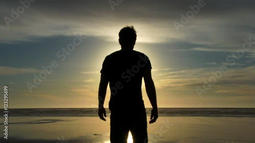 Model released person walking out on sandy beach shoreline to catch some rays, enjoy the breeze and relax at the Pacific Coast in Oregon.