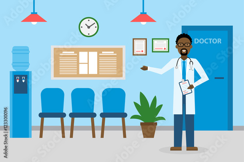 Doctor in waiting room. Handsome smiling african american man in white standing in waiting room. Hospital interior with chairs and health care information.