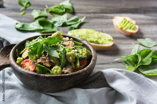 Spinach salad with avocado in the wooden bowl. Superfood. Fitness food.