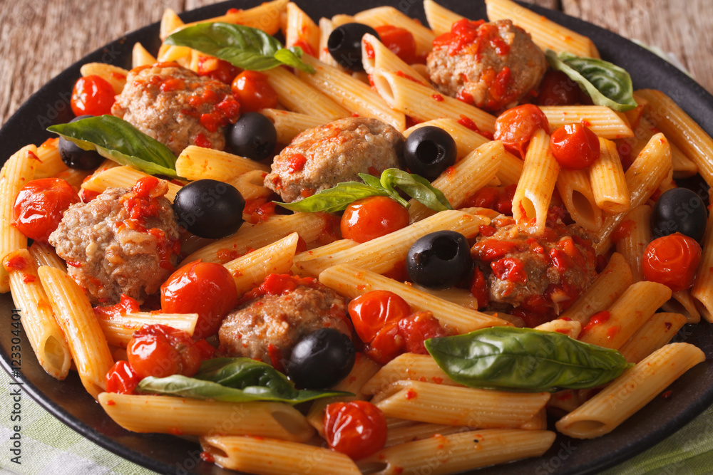 Penne pasta with meatballs and tomato sauce closeup. horizontal
