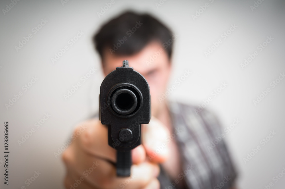 Crazy young man aiming gun at you Crazy young man aiming gun at you
