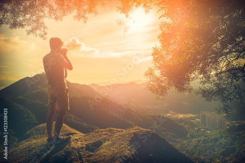 Man Traveler with photo camera outdoor Travel Lifestyle survival