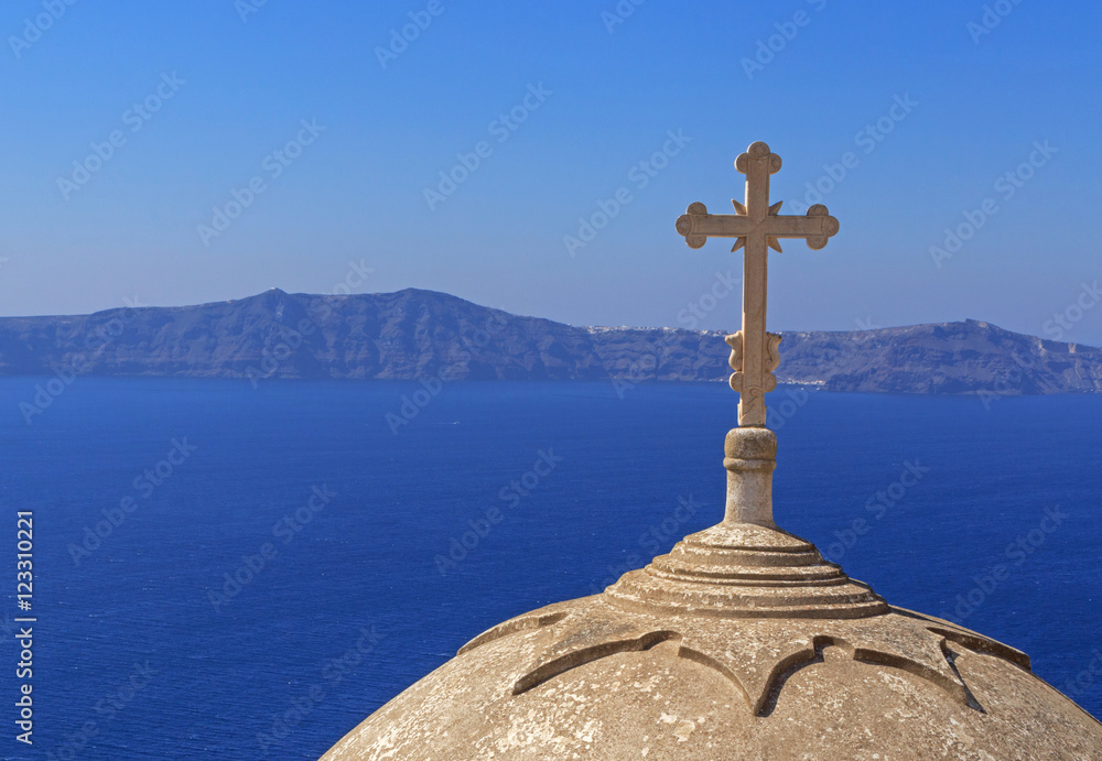 cross on dome of church in Fira against caldera