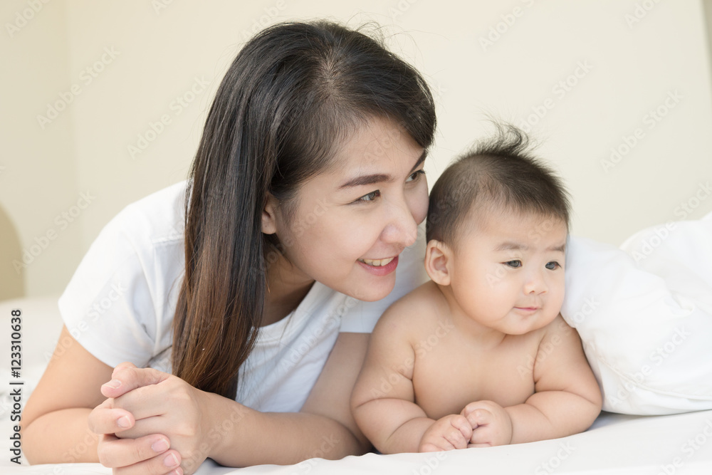 happy family.asian mother playing with her baby in the bedroom. happy family.asian mother playing with her baby in the bedroom.