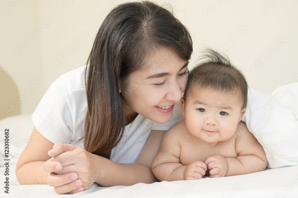 happy family.asian mother playing with her baby in the bedroom. happy family.asian mother playing with her baby in the bedroom.